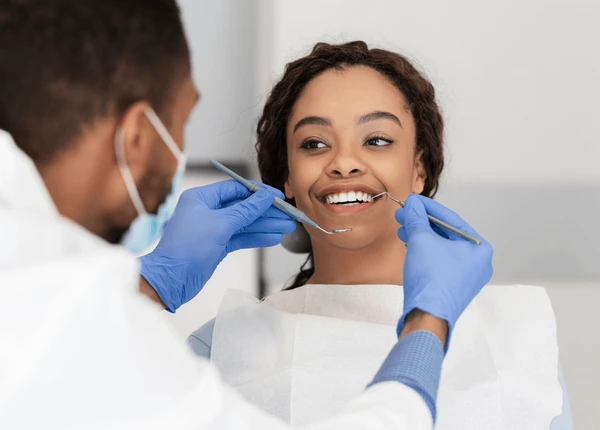 A smiling patient in a dental chair representing the "A Happy Mouth is a Happy Life" theme for World Oral Health Day.